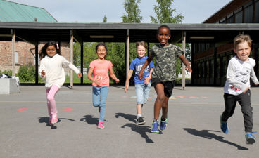 Barn som løper i skolegård