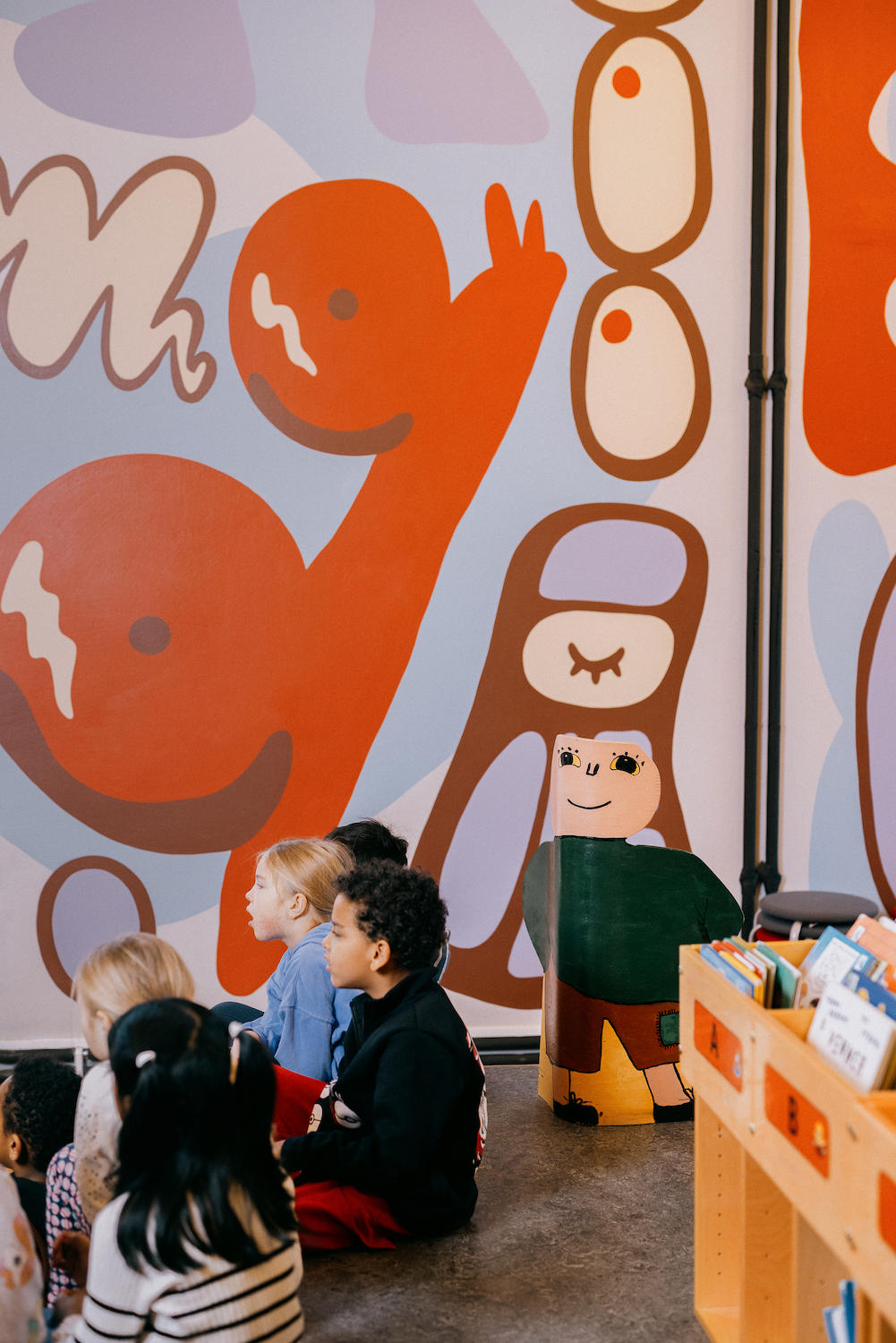 en gruppe mennesker som ser på en vegg med en tegneserie