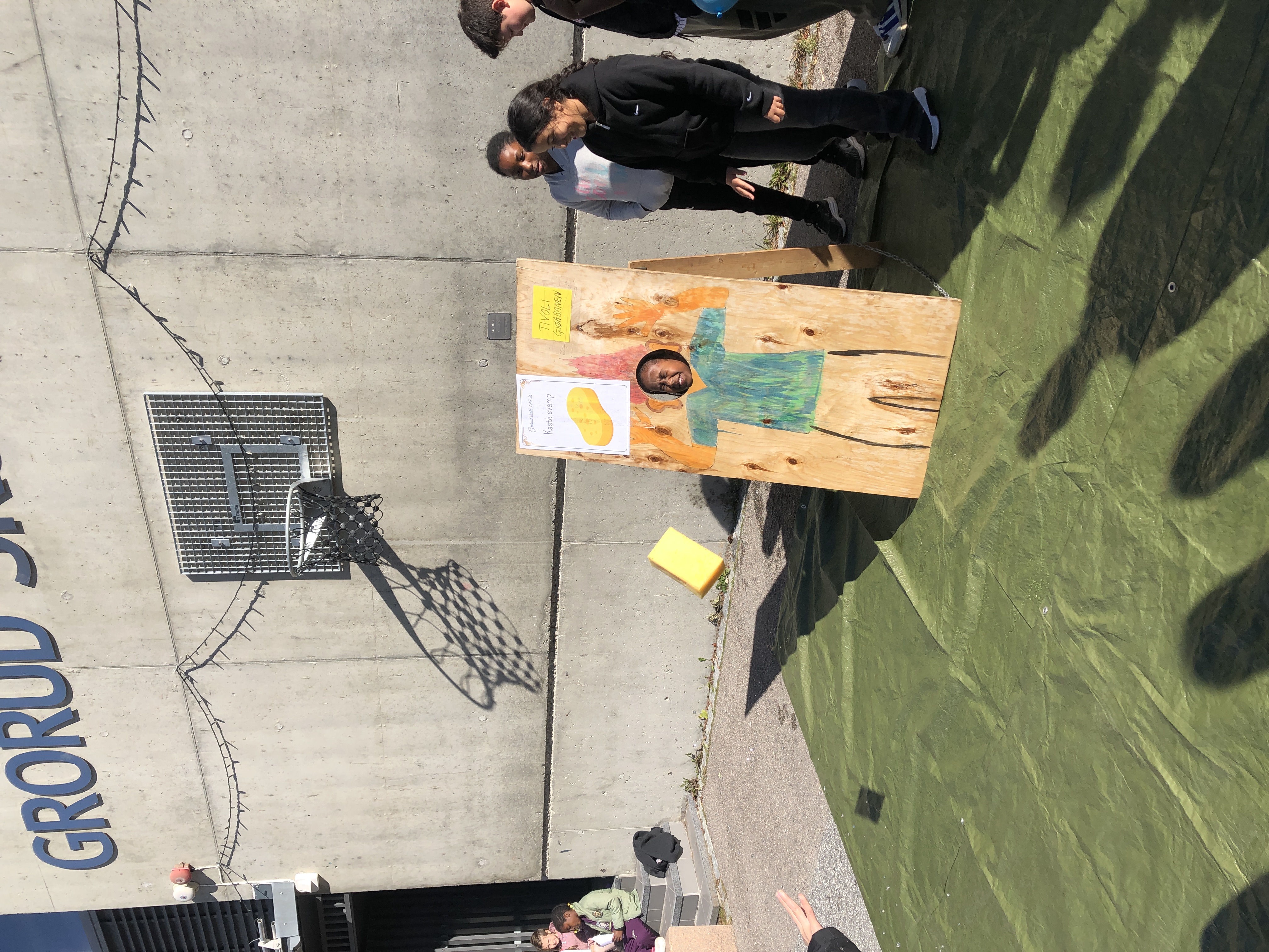 en gruppe mennesker som står ved siden av et maleri på en vegg