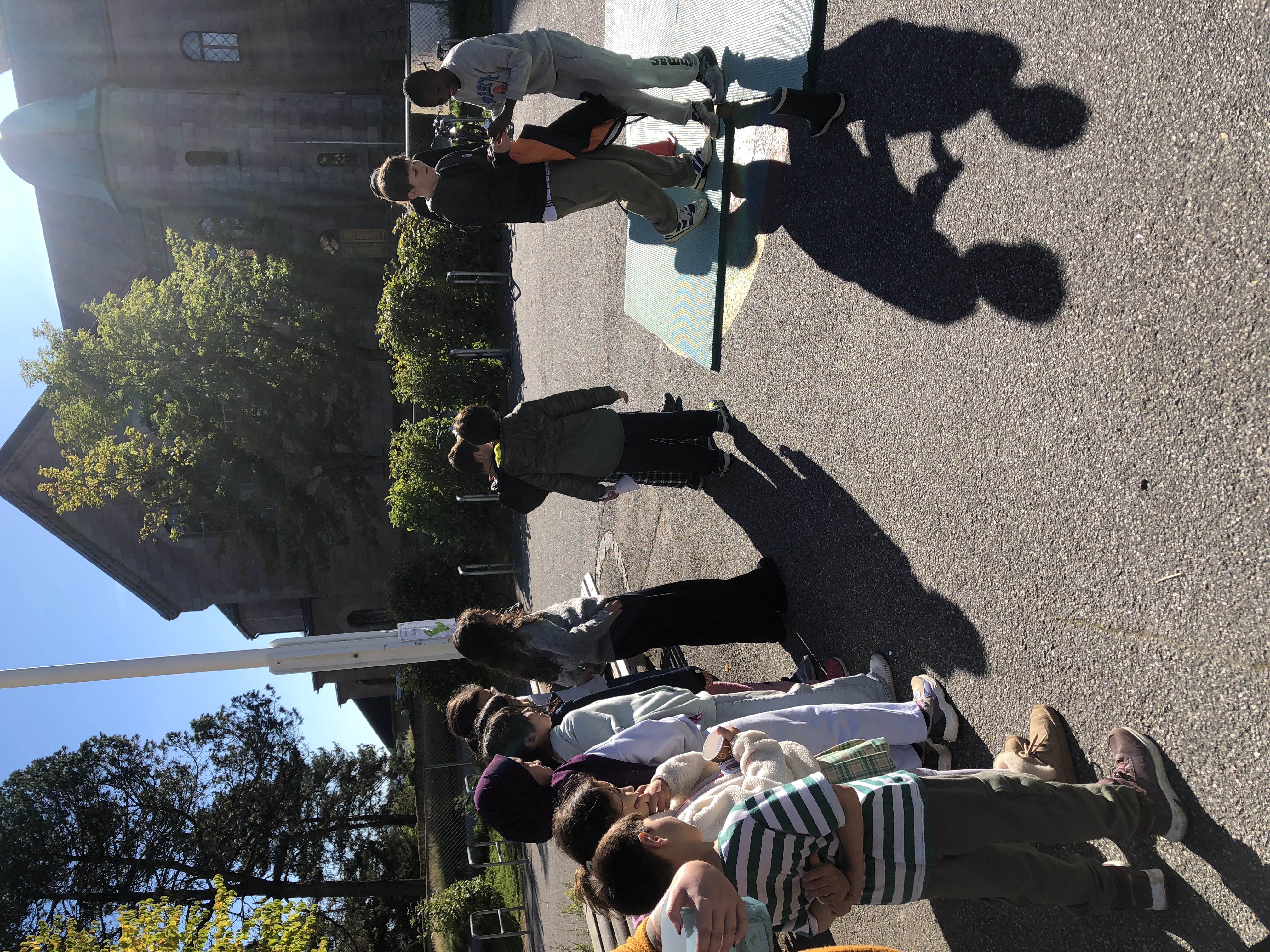 en gruppe mennesker som står på et fortau