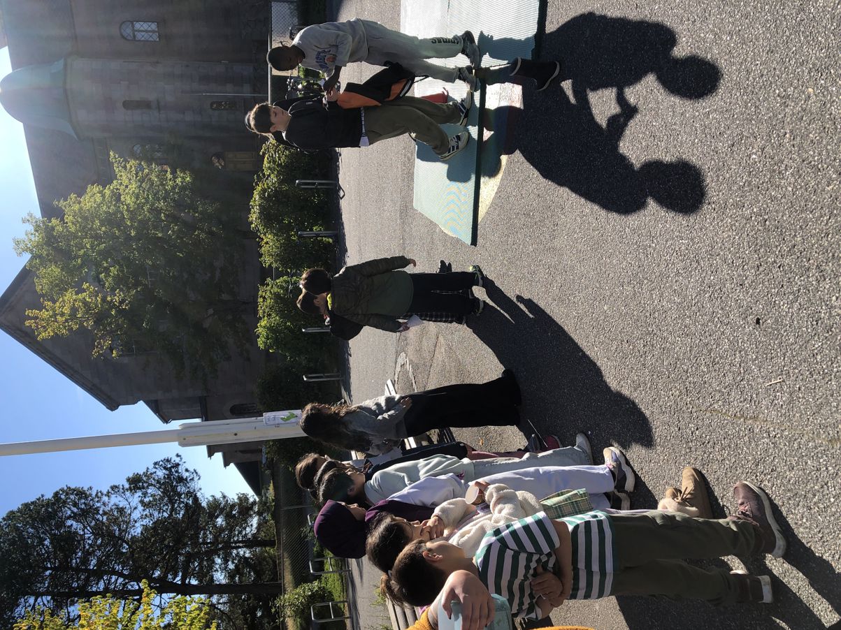 en gruppe mennesker som står på et fortau