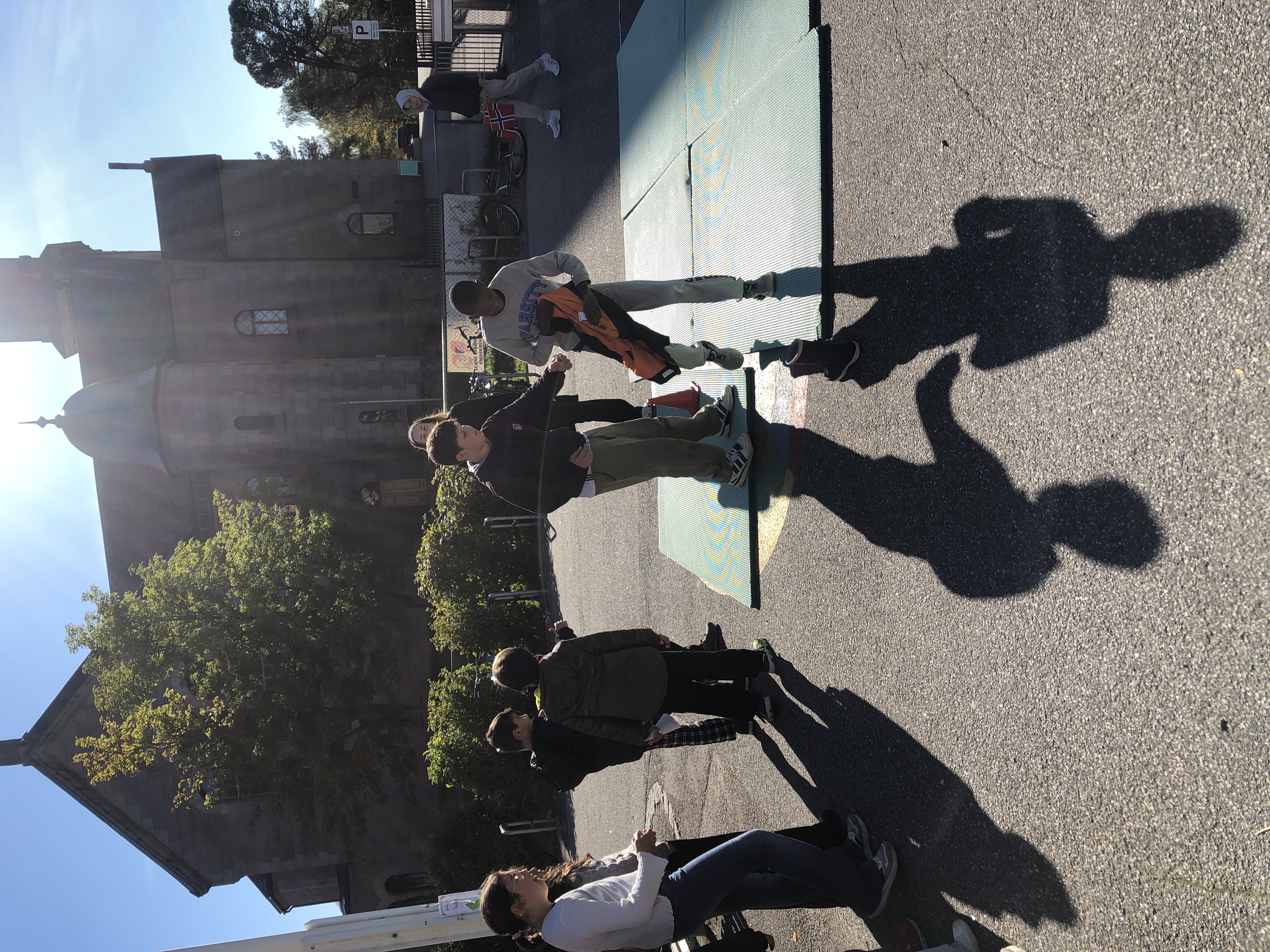 en gruppe mennesker som står på et fortau